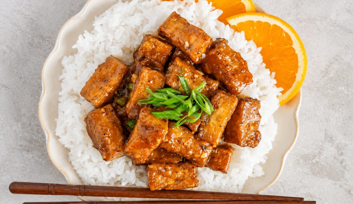 Crispy orange tofu coated in a sweet and sticky homemade orange sauce served over rice with green onions and sesame seeds.