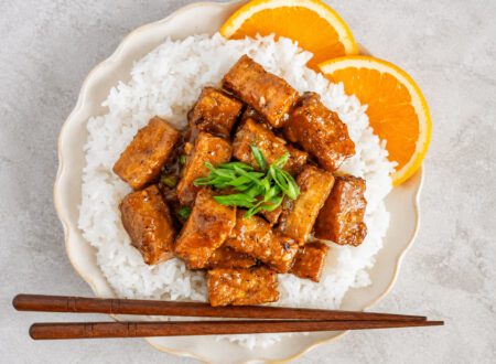 Crispy orange tofu coated in a sweet and sticky homemade orange sauce served over rice with green onions and sesame seeds.