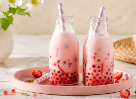 Glass of homemade strawberry boba tea with fresh strawberries and chewy tapioca pearls.