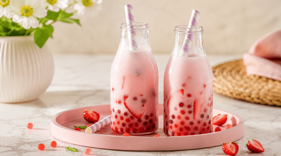 Glass of homemade strawberry boba tea with fresh strawberries and chewy tapioca pearls.