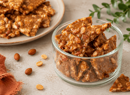 Homemade almond brittle broken into crunchy golden pieces with roasted almonds.