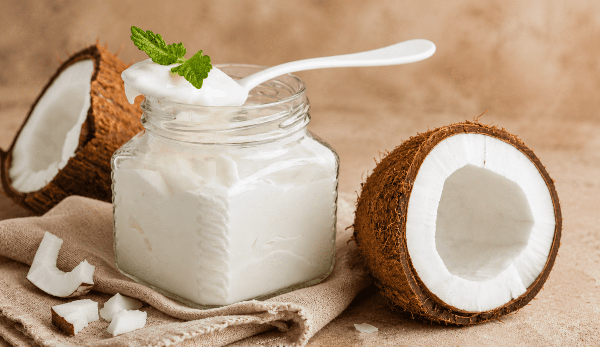 Creamy homemade coconut milk yogurt served in a glass jar with fresh fruit on top.