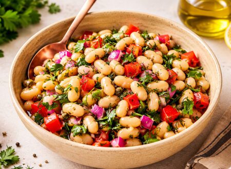 Bowl of Tuscan white beans cooked with garlic, herbs, tomatoes, and fresh parsley.