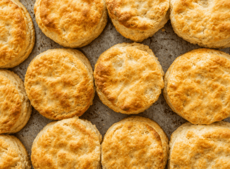 Freshly baked vegan biscuits with a golden crust served on a rustic plate.