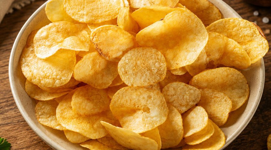Crispy homemade oil-free potato chips served in a bowl with seasoning sprinkled on top.