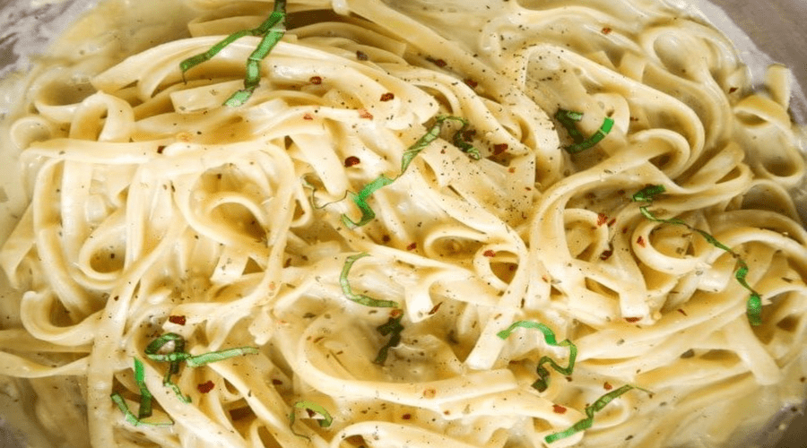 Assortment of vegan pasta sauces served with different pasta dishes on a table.